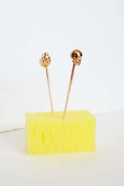Skull beads painted gold and drying in a foam block