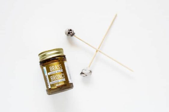 Bottle of liquid leaf and two beads on bamboo skewers