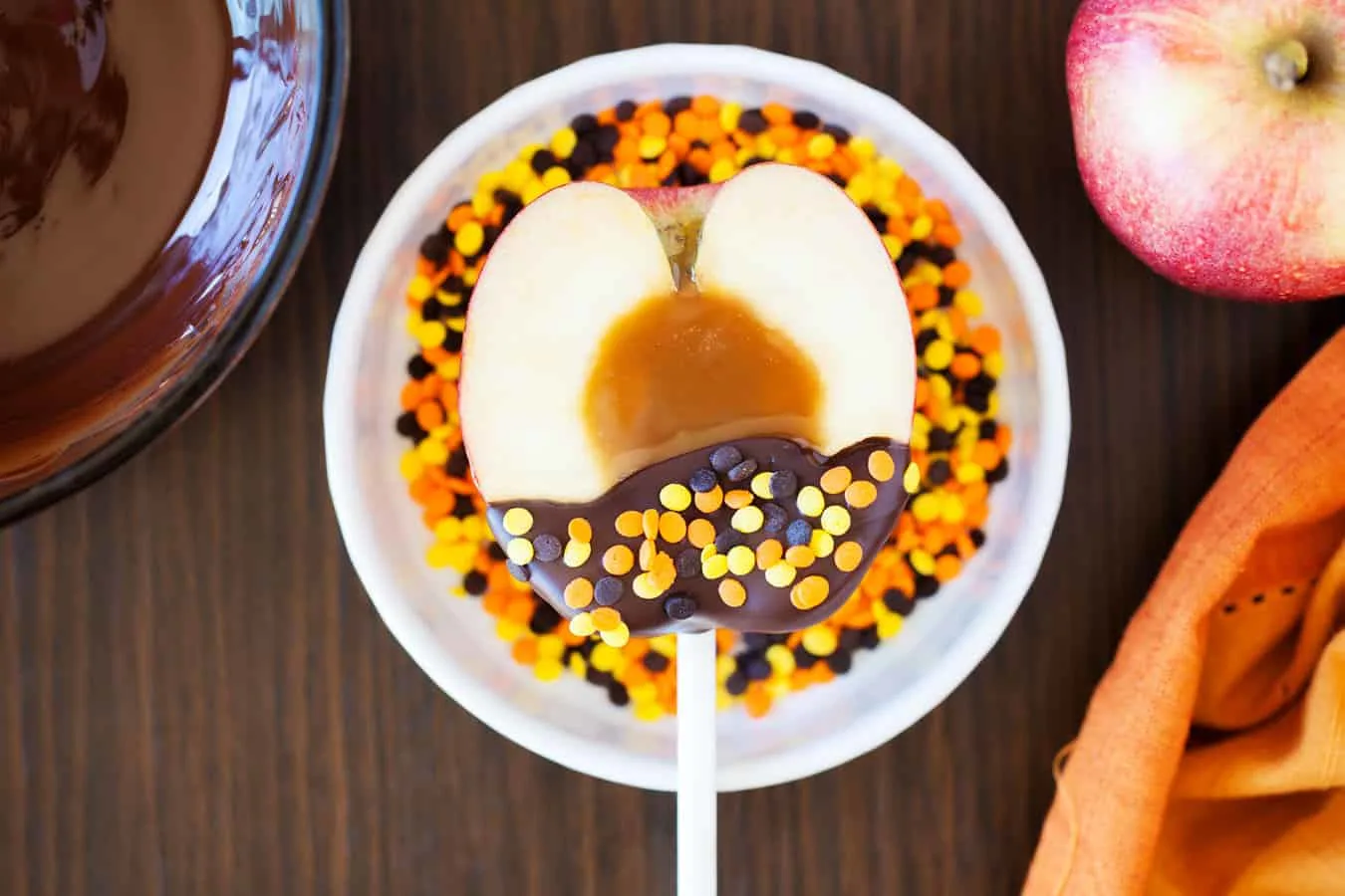 Learn how to make delicious candy apples on a stick. These caramel apple pops are perfect for fall and you can customize with the toppings of your choice!