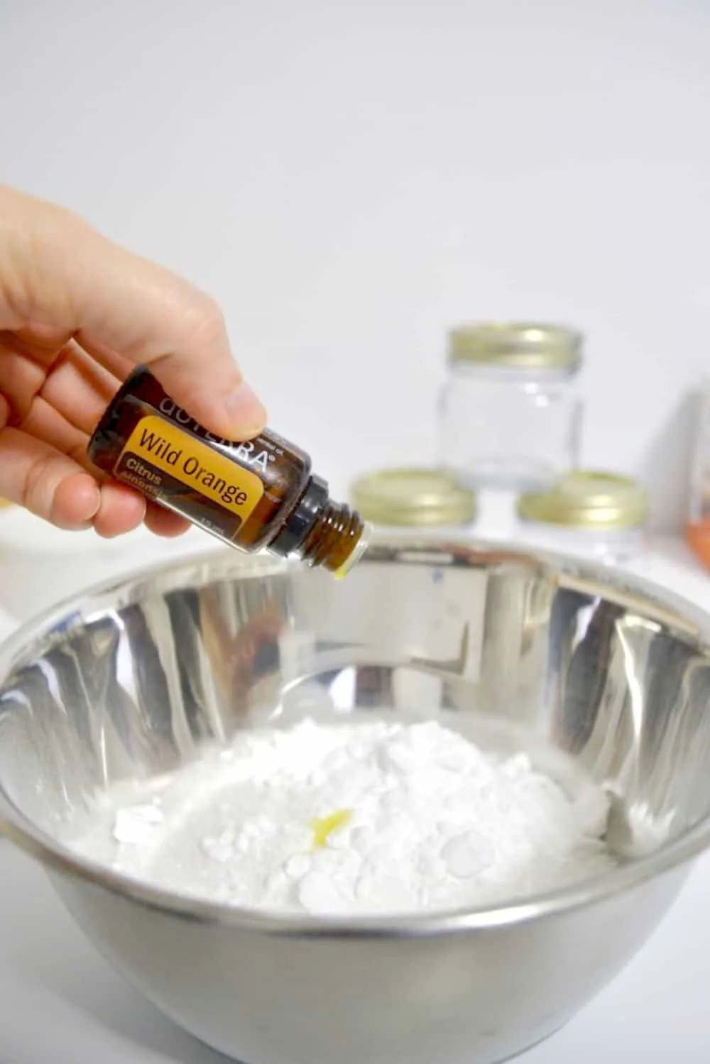 Dropping essential oils on baking soda and epsom salt to make bath salts