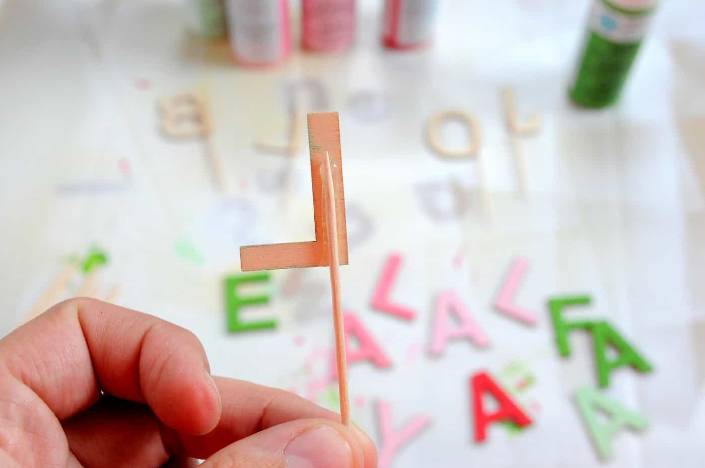 Gluing a toothpick to the back of a wood letter