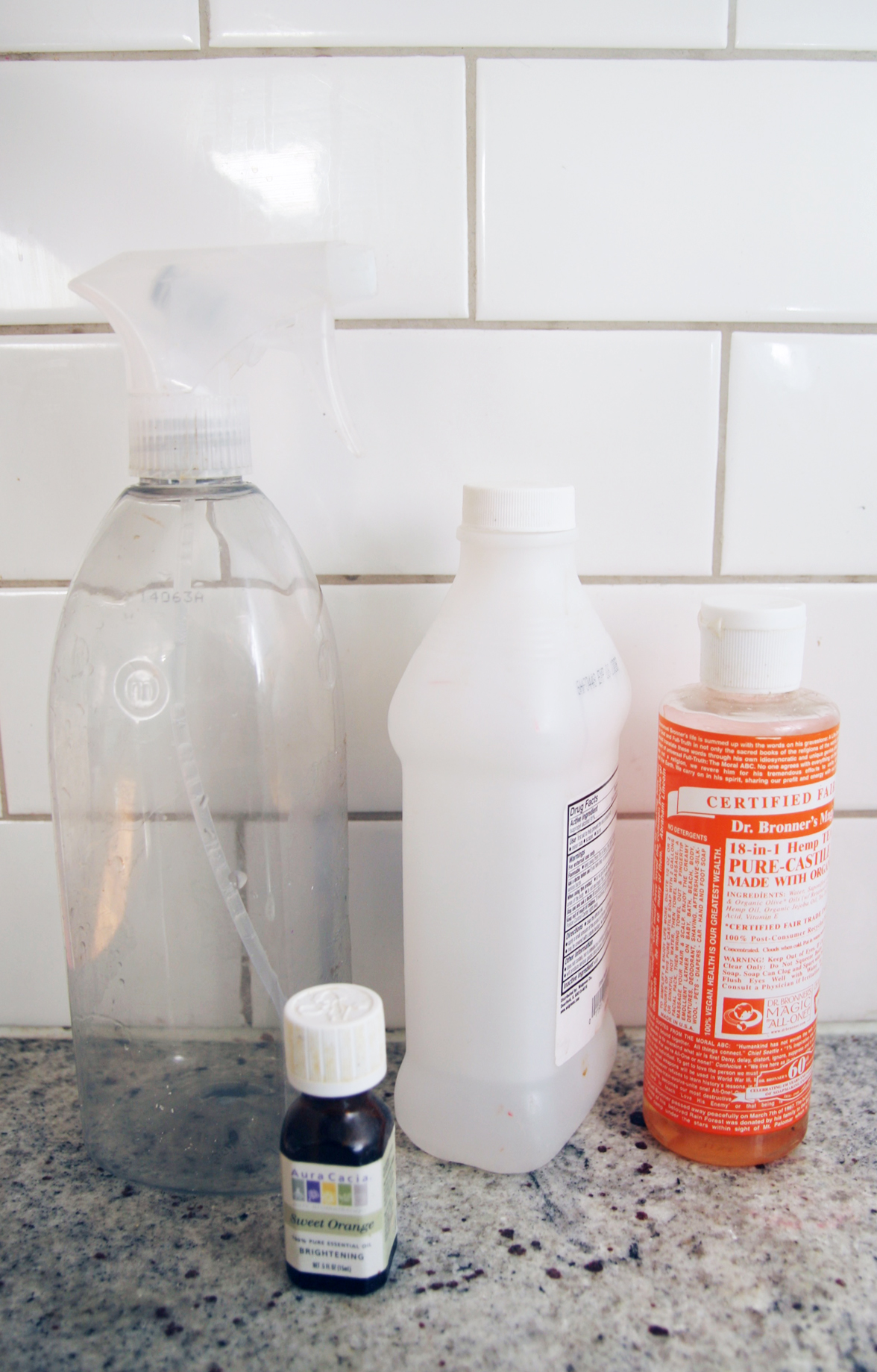 Empty spray bottle, rubbing alcohol, Dr. Bronner's soap, and essential oils