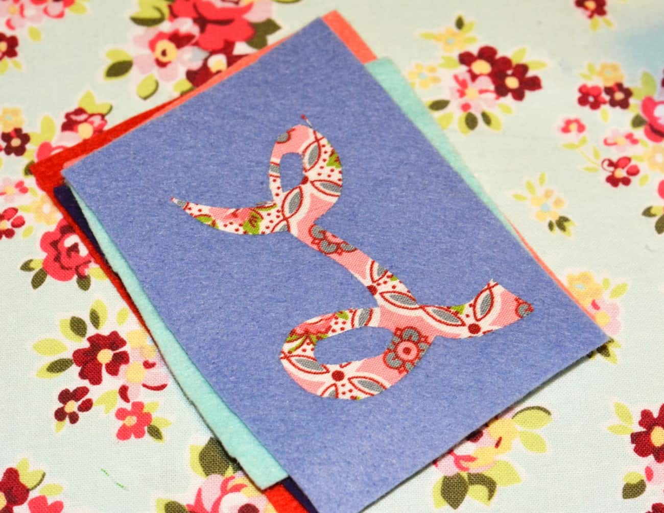 Fabric letter L ironed on to a piece of felt