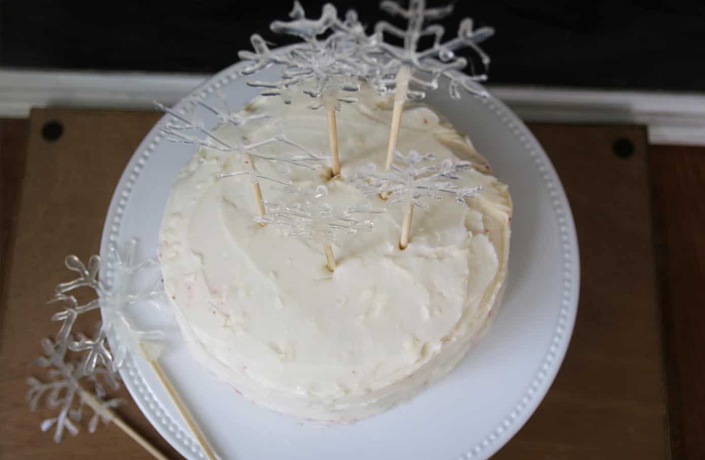 Snowflake cake toppers inserted in a white frosted cake on a white plate