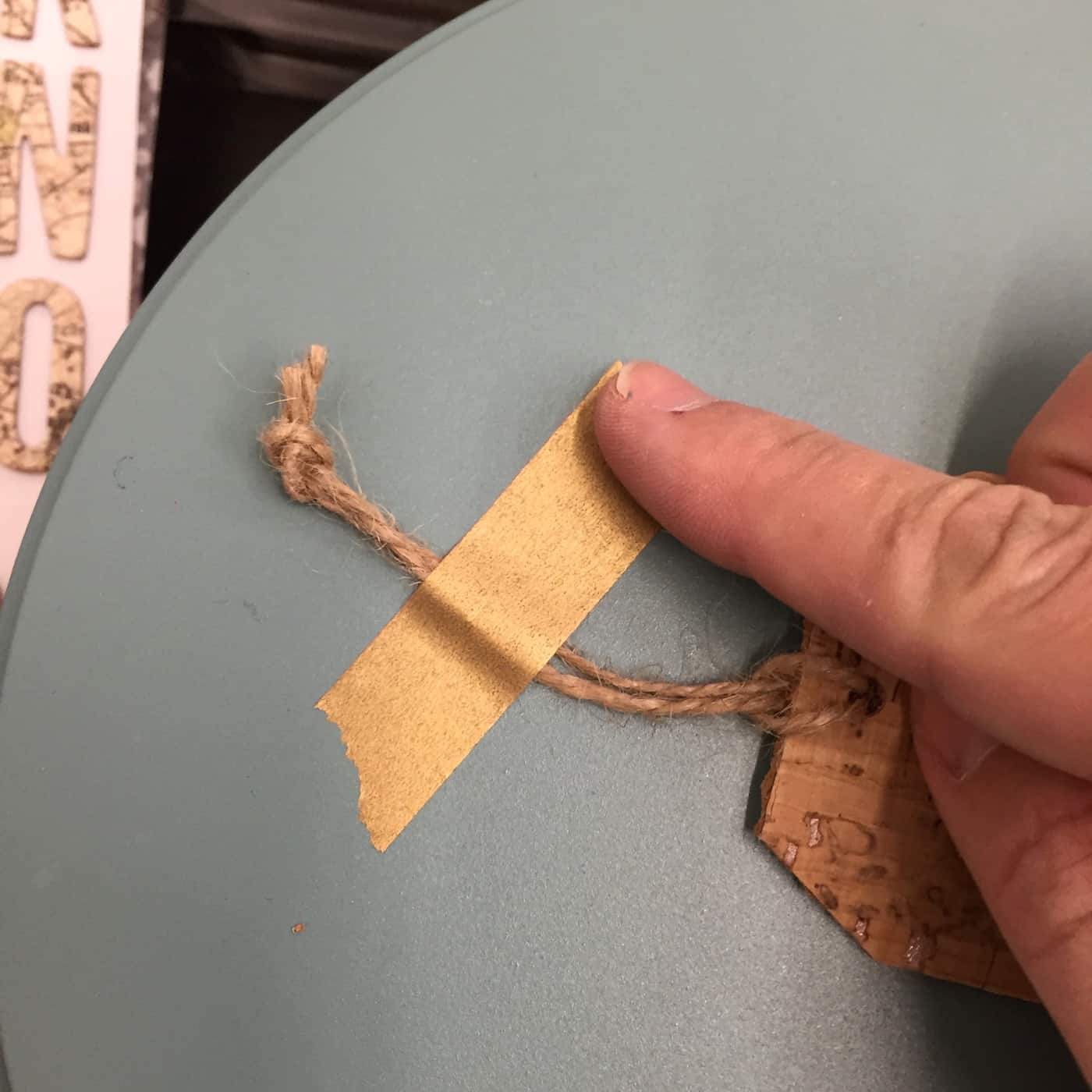 Taping a tag to the top of a metal lid with washi tape