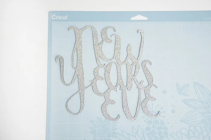New Year's Eve glitter cutout stuck to a Cricut mat