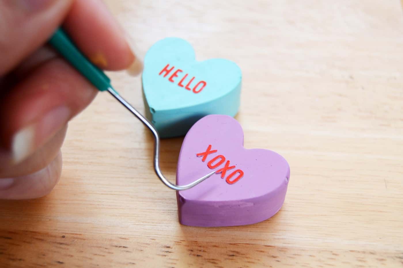 Adhering letters to the hearts and using a small tool to place them