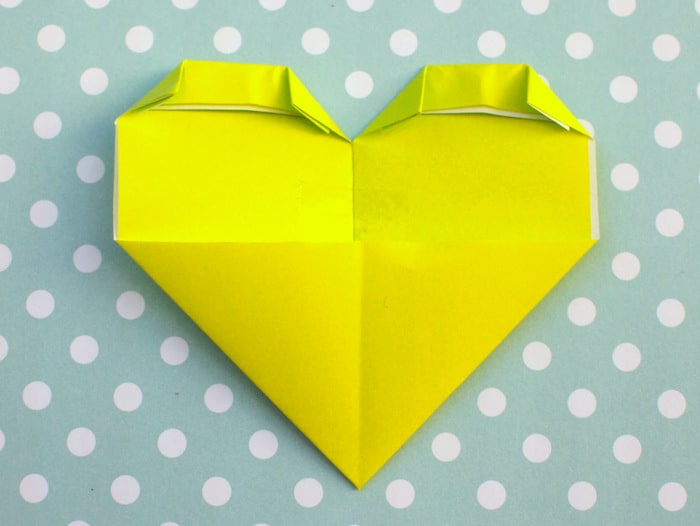 Folding down the corners on either side of the top of the heart