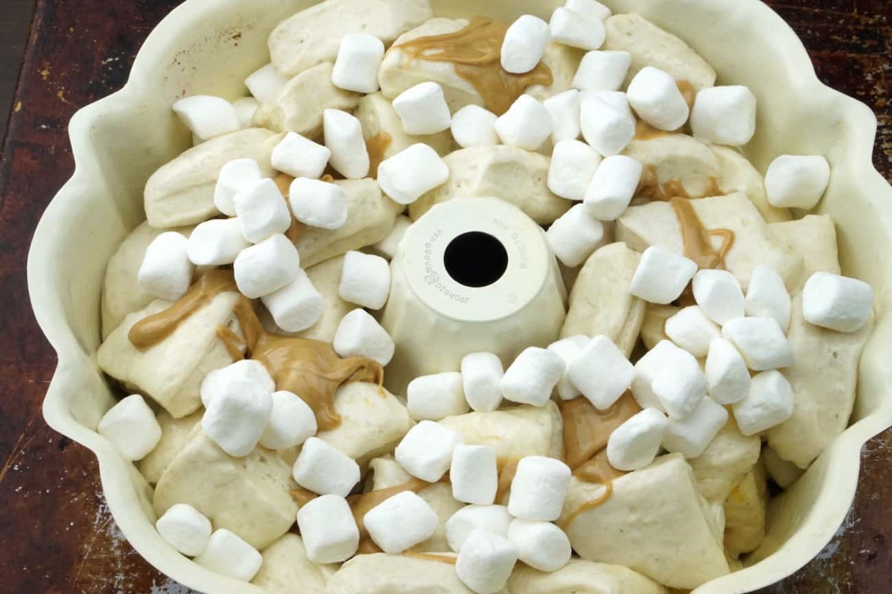 Biscuit pieces, peanut butter, and marshmallow in a bundt pan