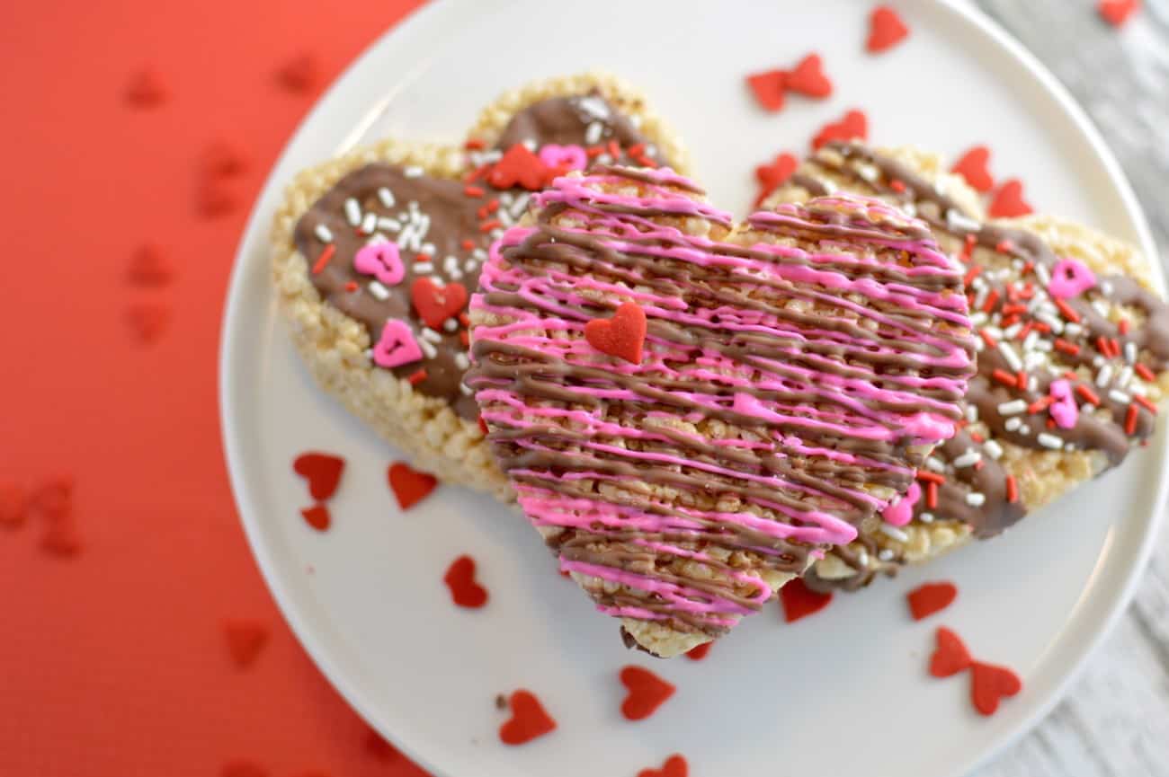 This Rice Krispie treat recipe is made extra awesome for Valentine's Day with the heart shape and the addition of chocolate drizzle and sprinkles. So fun!