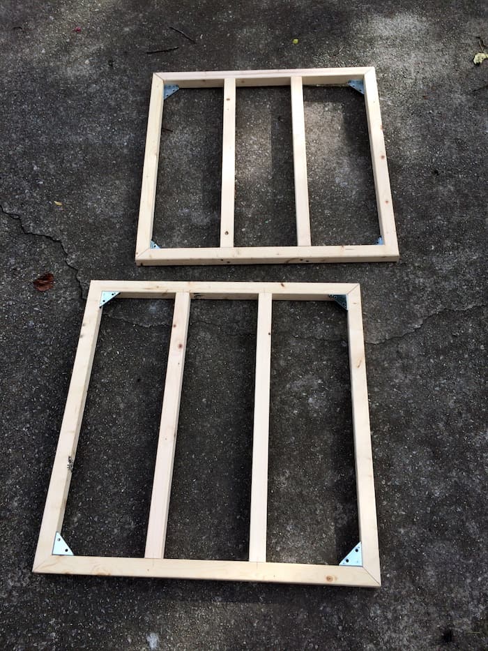 Two wood frames on the ground with the crossbars screwed in