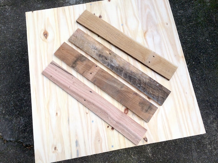 Four pieces of pallet wood on the top of a piece of plywood