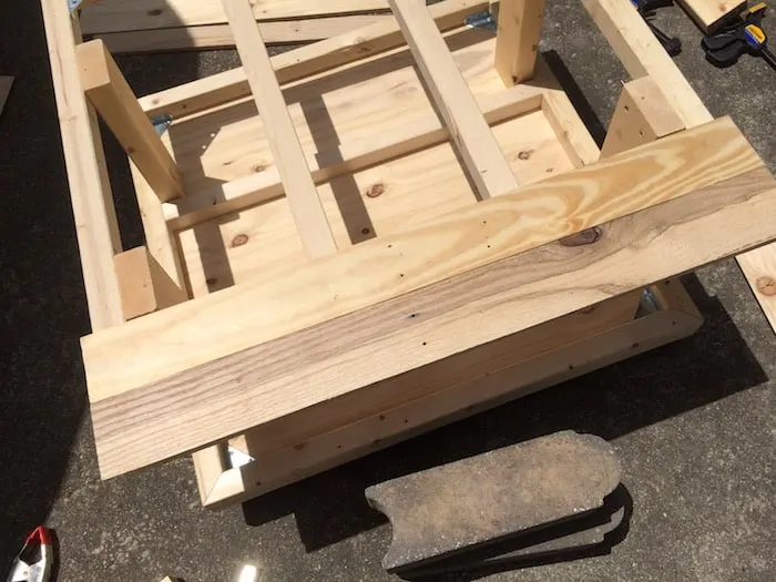 Partially assembled table with one of the boards across the top of the coffee table frame