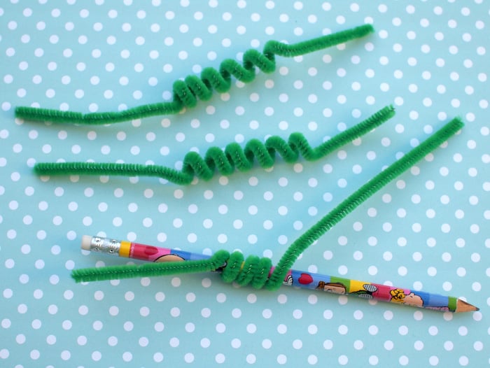 Green pipe cleaners winding around a pencil