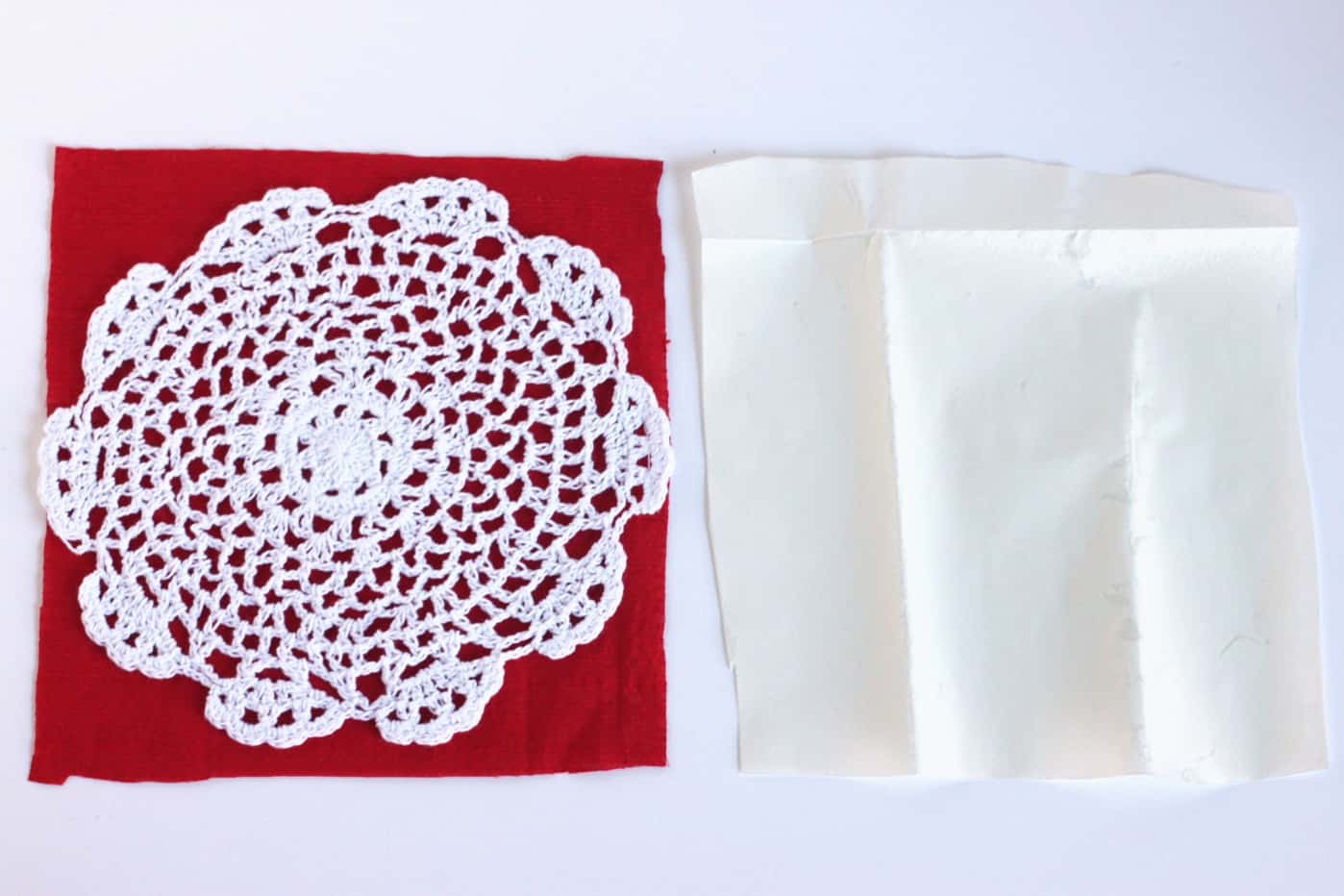 Doily on top of a piece of red fabric with a piece of Heat n' Bond sitting next to it