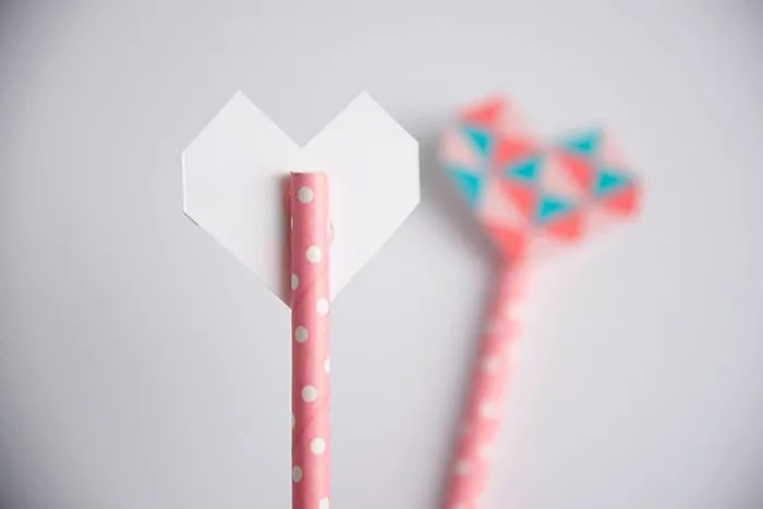 Gluing the paper hearts to the straws