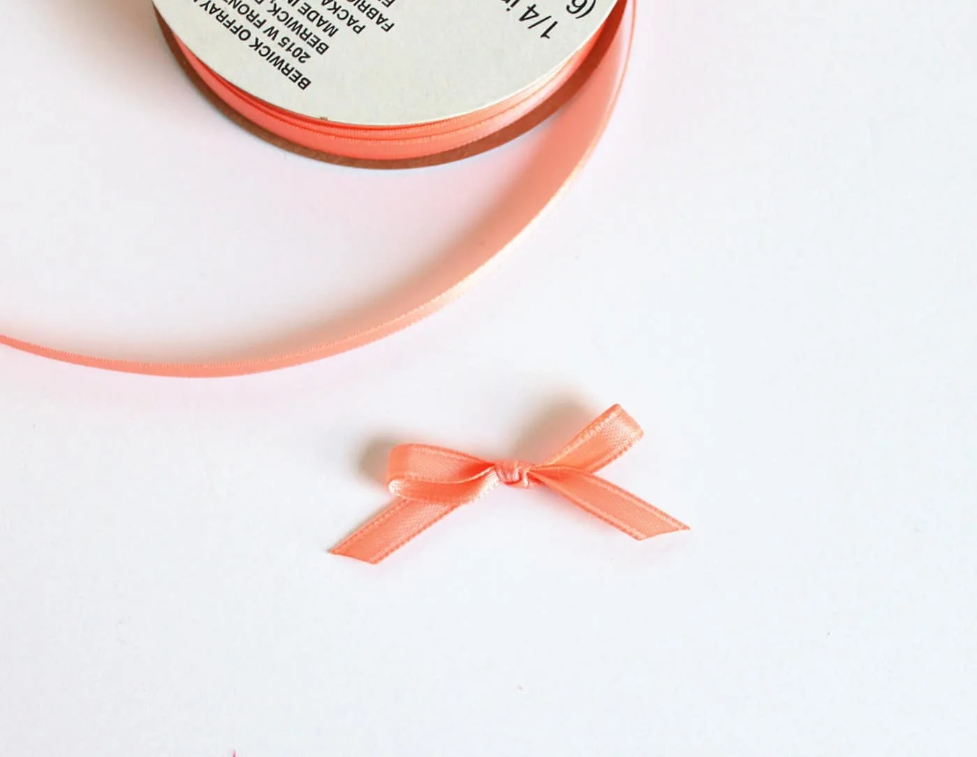 Bow tied with a roll of peach ribbon