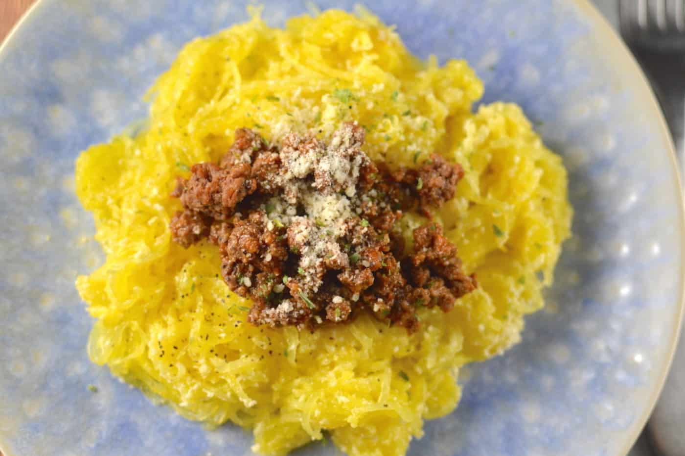 Cooked spaghetti squash with meat tomato sauce and parmesan cheese