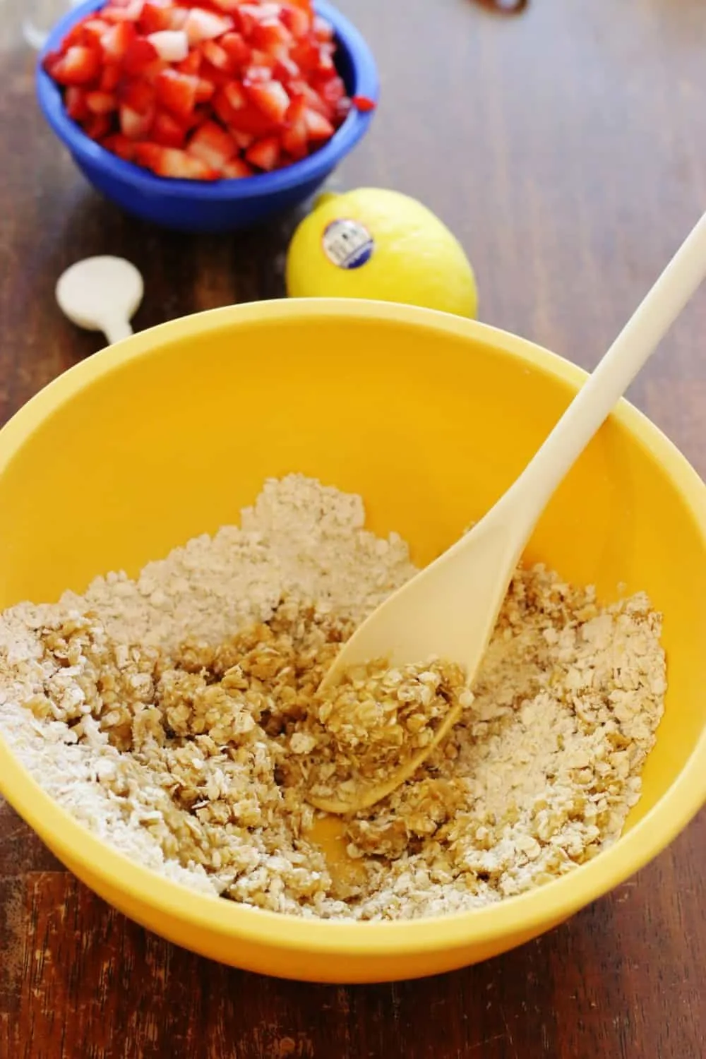 Mixing butter together with oats in a yellow bowl