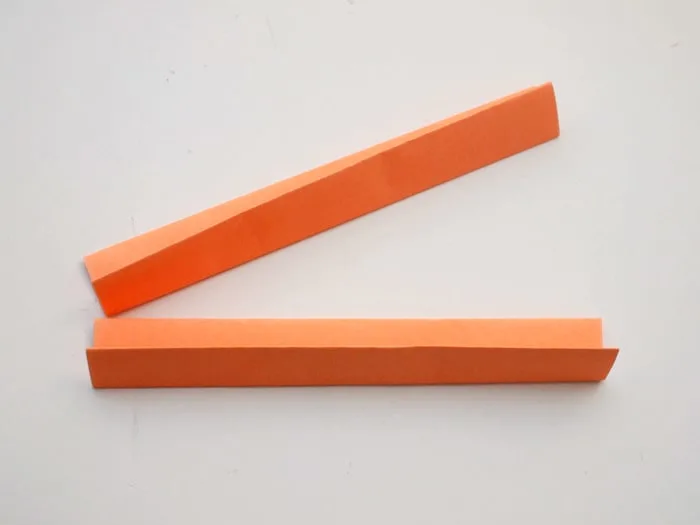 Two sheets of orange origami paper folded in half