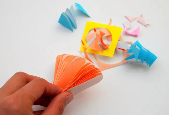 Origami sheets folded in half with the ends trimmed