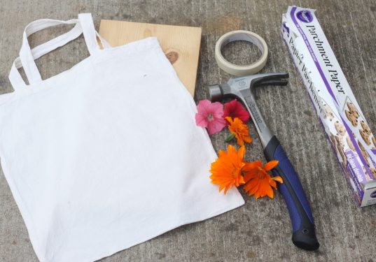 White canvas tote, wood board, flowers, hammer, parchment paper