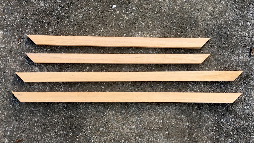 Four wood frame pieces with 45 degree angles cut at both ends