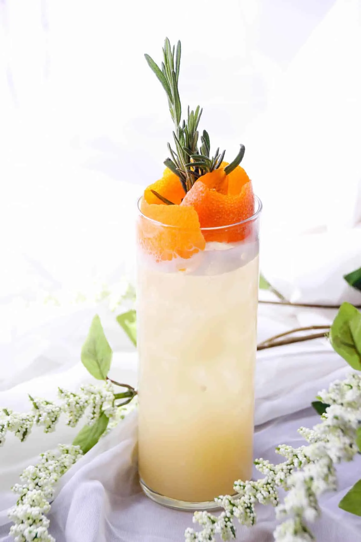 Coconut vodka drink recipe in a glass with orange rind