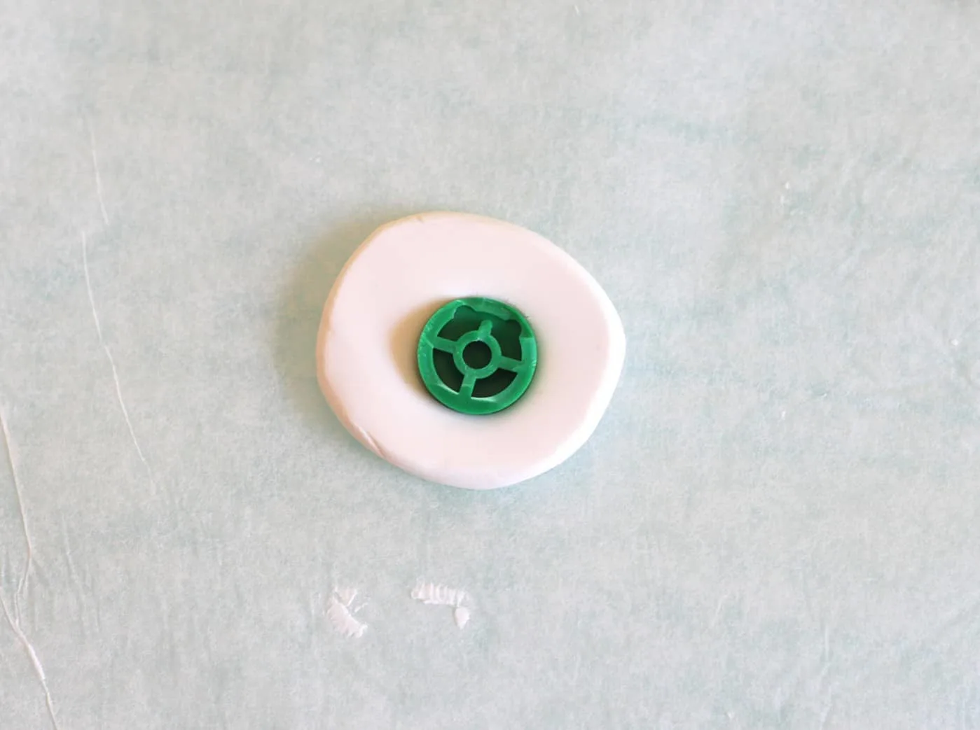 Pressing the Nintendo 64 button face down into white clay