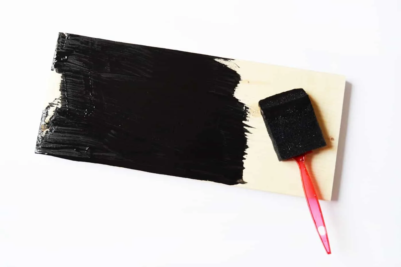 Painting the pine board in black using a foam brush
