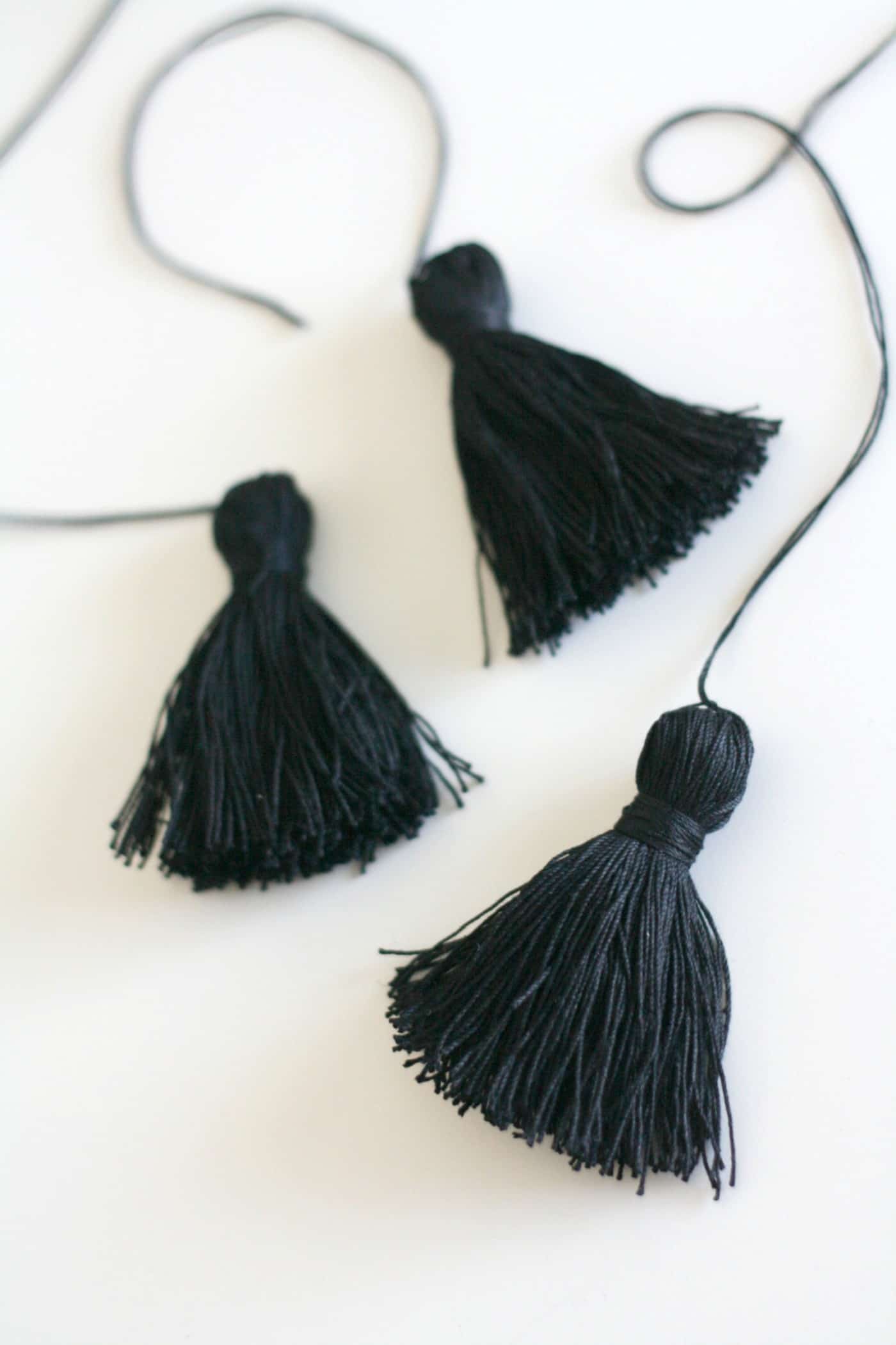 Three black tassels made with embroidery floss