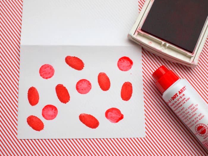 Red fingerprints made on the front of the card using a red ink pad