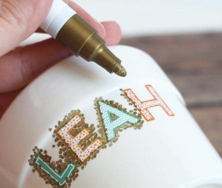 Dotting a white ceramic pot with a Sharpie paint marker