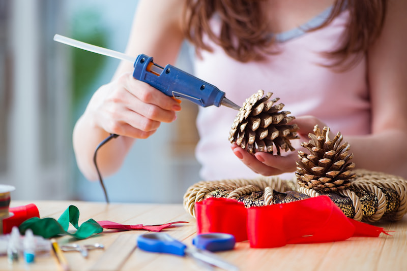Hot gluing a pine cone for crafts