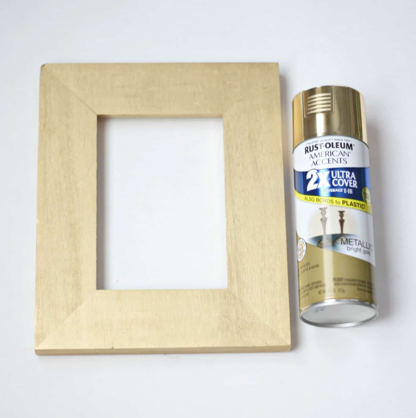 Rectangular wood frame and a gold can of spray paint