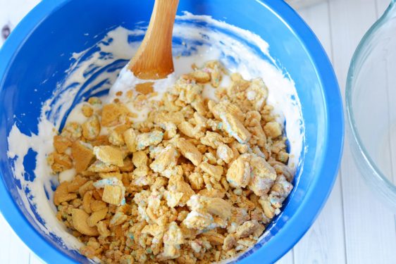 Stirring oreos into marshmallows in a blue bowl