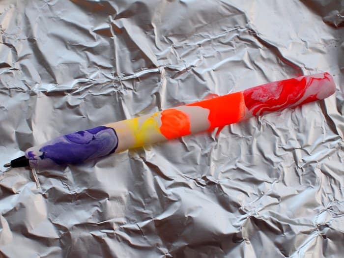 Polymer clay pen laying on a piece of aluminum foil