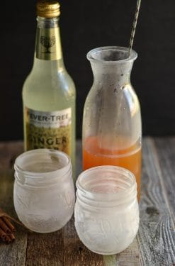 chilled mason jar glasses with apple cider in the background