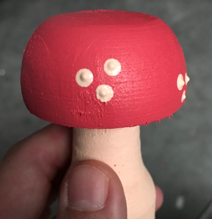Painting the spots on the wood mushroom