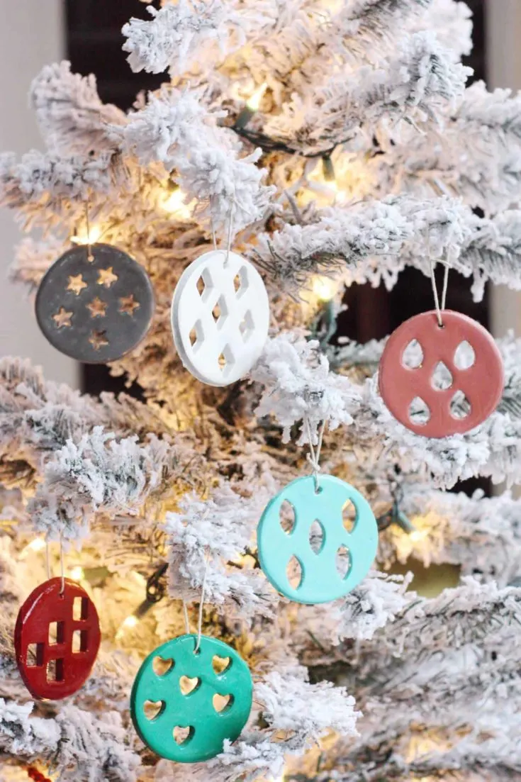 DIY clay Christmas ornaments hanging from a frosted tree