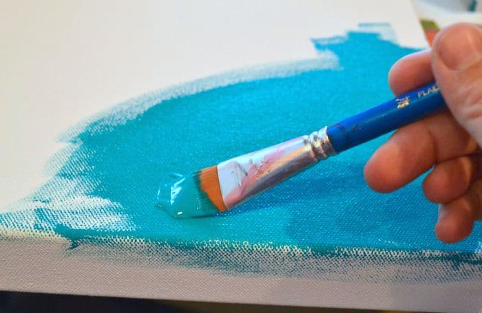 Painting a canvas with aqua paint