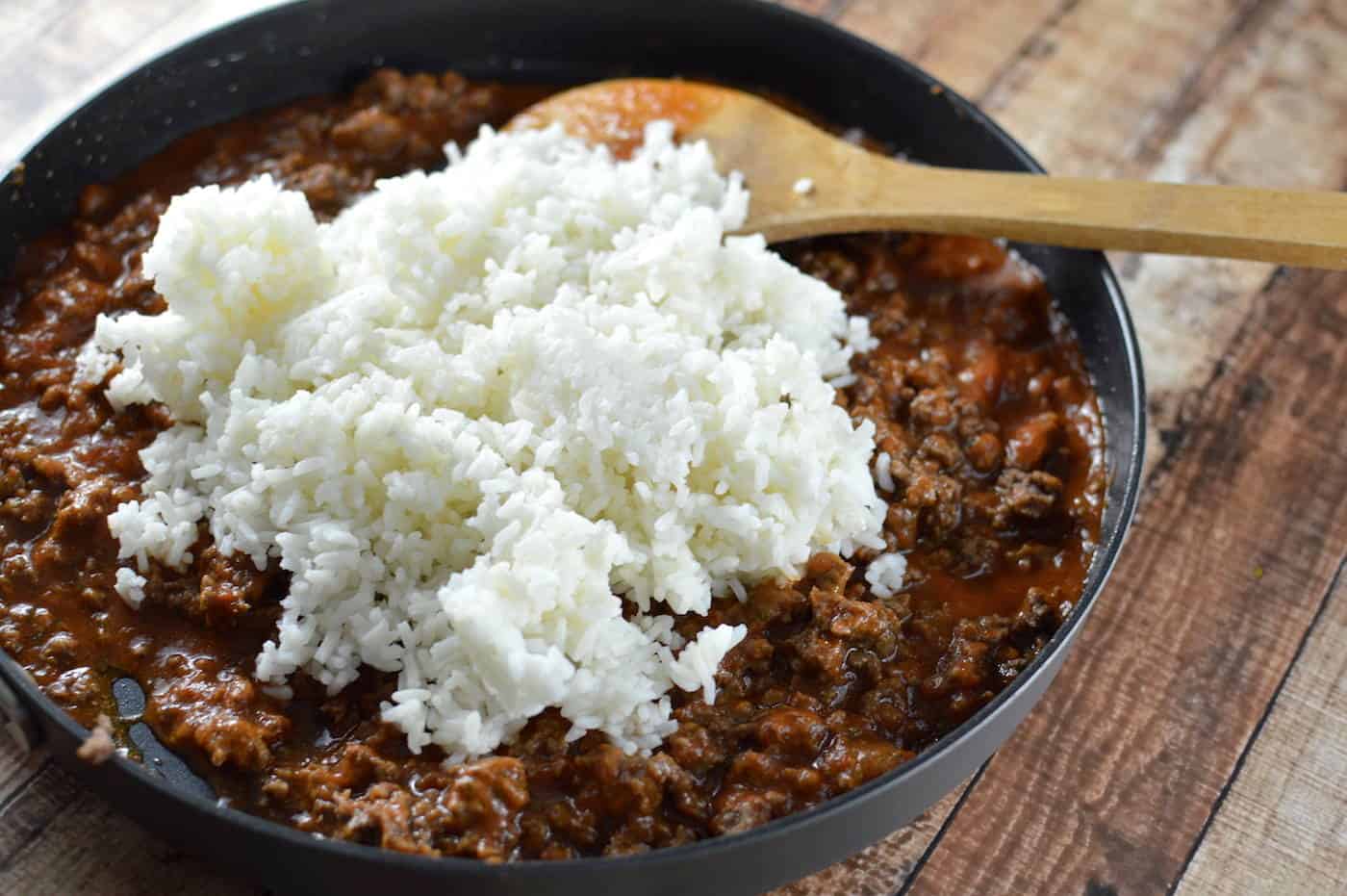 Adding rice to a pan of ground beef