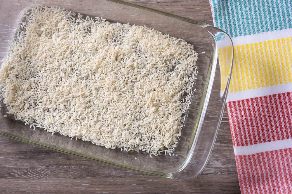 Rice sprinkled in the bottom of a casserole dish