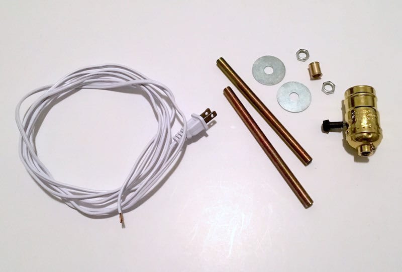 Supplies to make a lamp including a cord, brass pipe, fittings, and washers