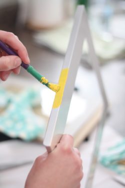 Woman painting the edges of a picture frame