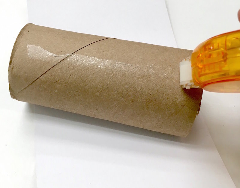 Run a glue strip down a toilet paper tube