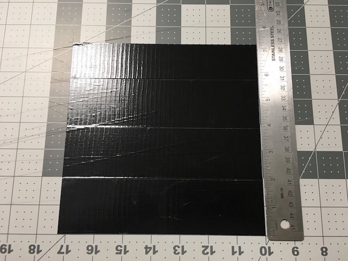 Making a black square of duck tape on a craft mat