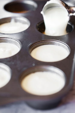 Pouring cheesecake mixture into a muffin tin using a scoop