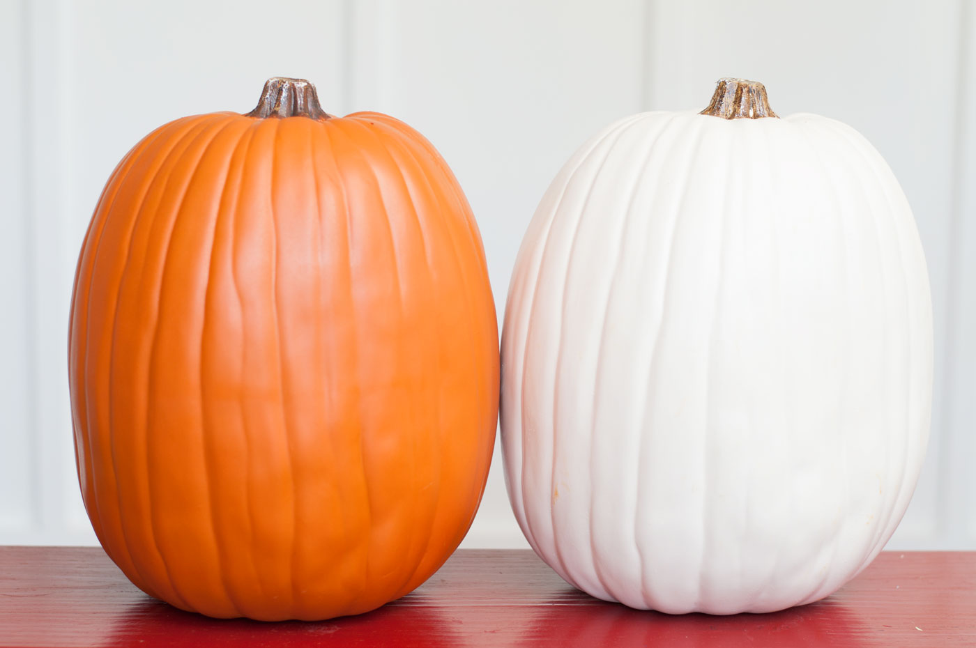 One faux orange pumpkin and one faux white pumpkin
