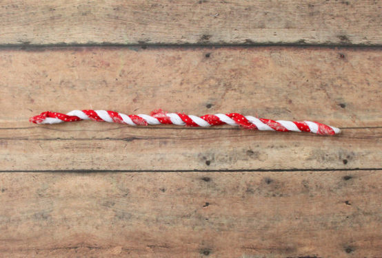 Piece of wire with red and white fabric strips twisted around it